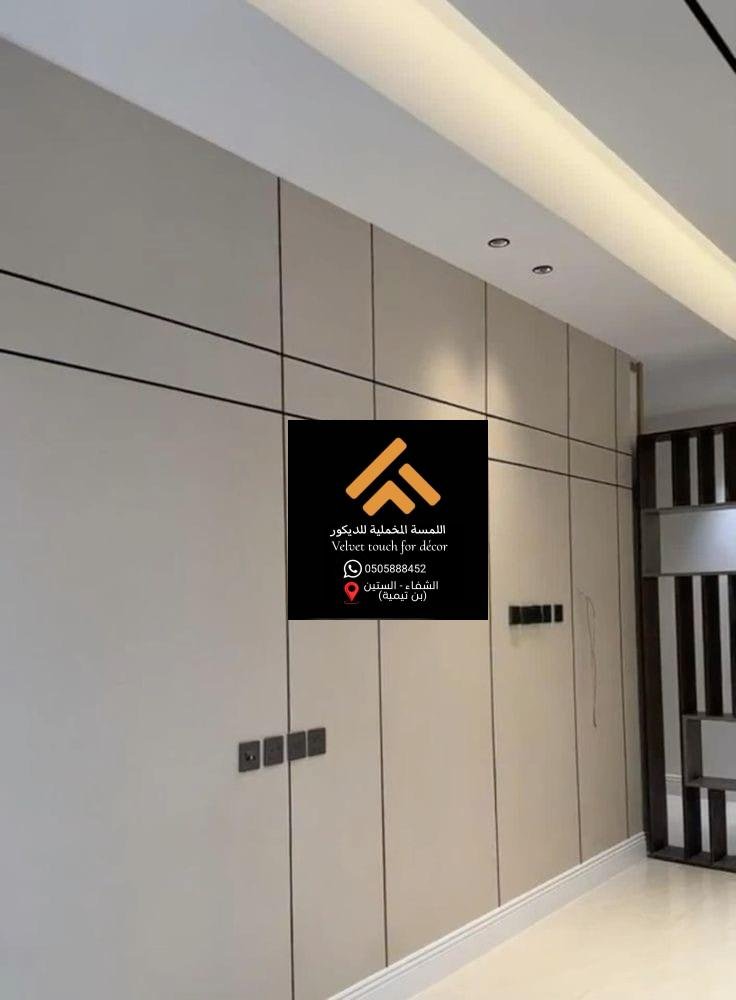 جدار داخلي من الخشب الطبيعي مع إضاءة خفية تضيف دفئًا للمكان.