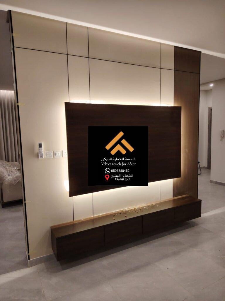جدار تلفزيون بتصميم خشبي مميز مع إضاءة جانبية.